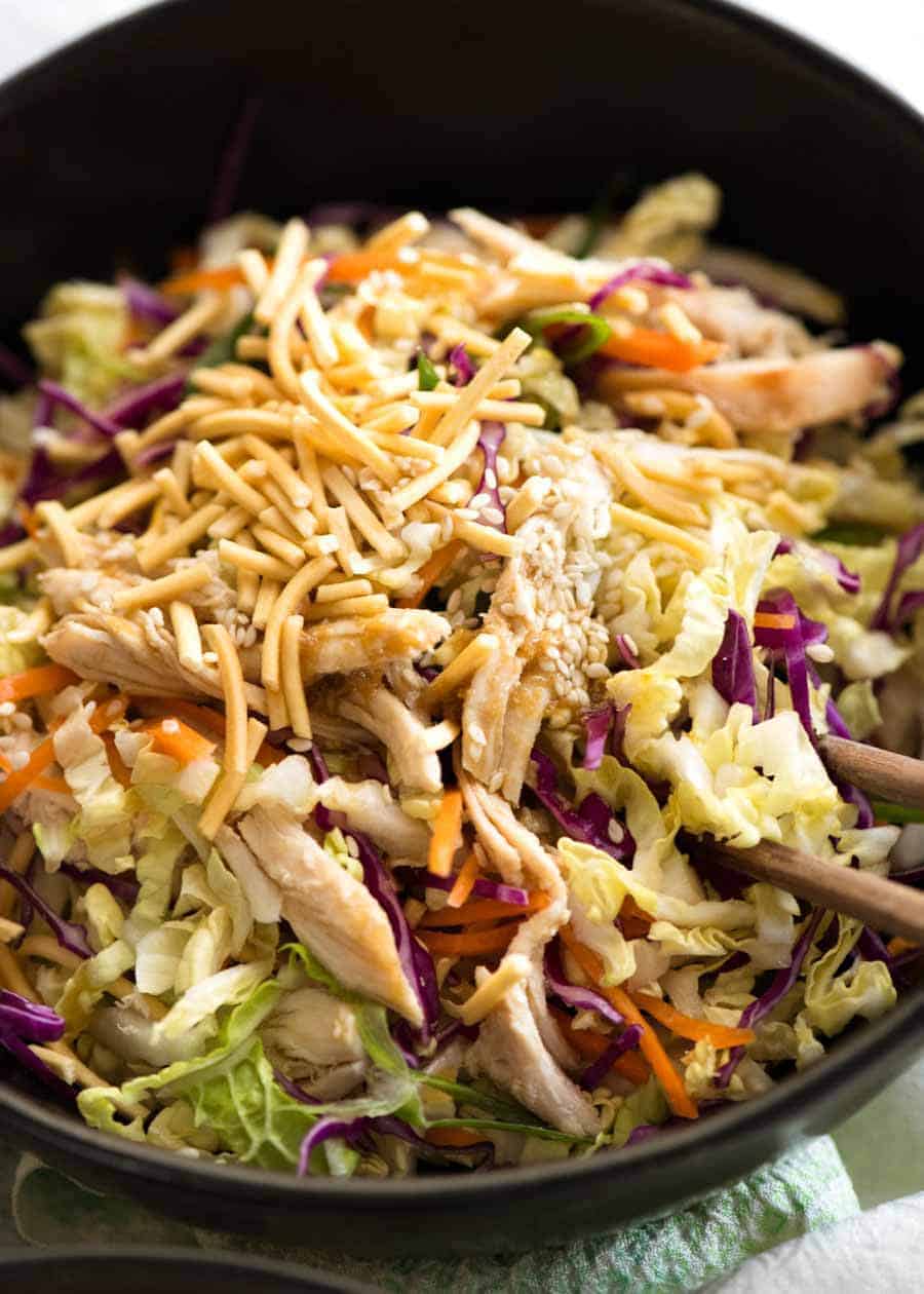 Close up of Chinese Chicken Salad with Asian Dressing in a rustic dark brown bowl, ready to be eaten
