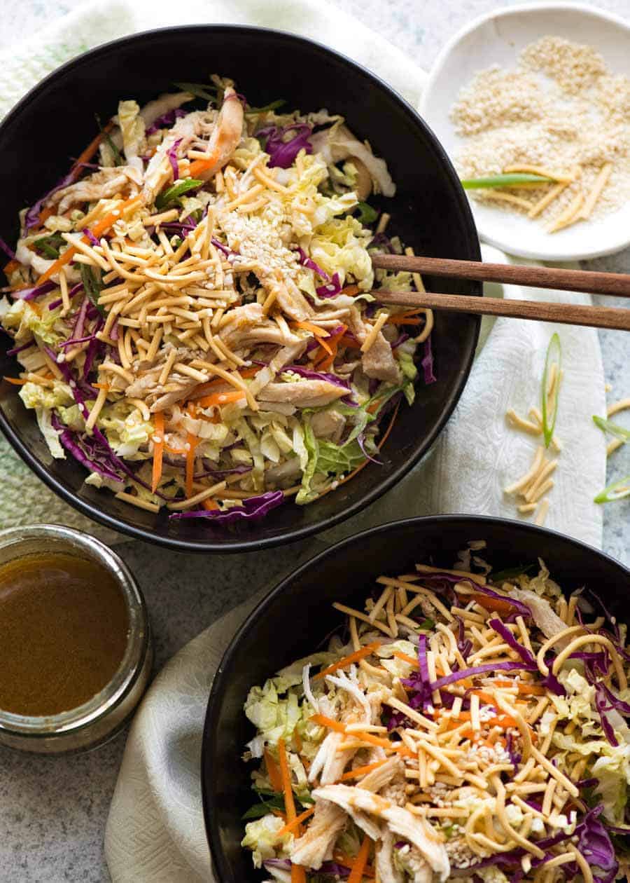 Overhead photo of 2 black bowls with Chinese Chicken Salad with Asian Dressing, ready to be eaten