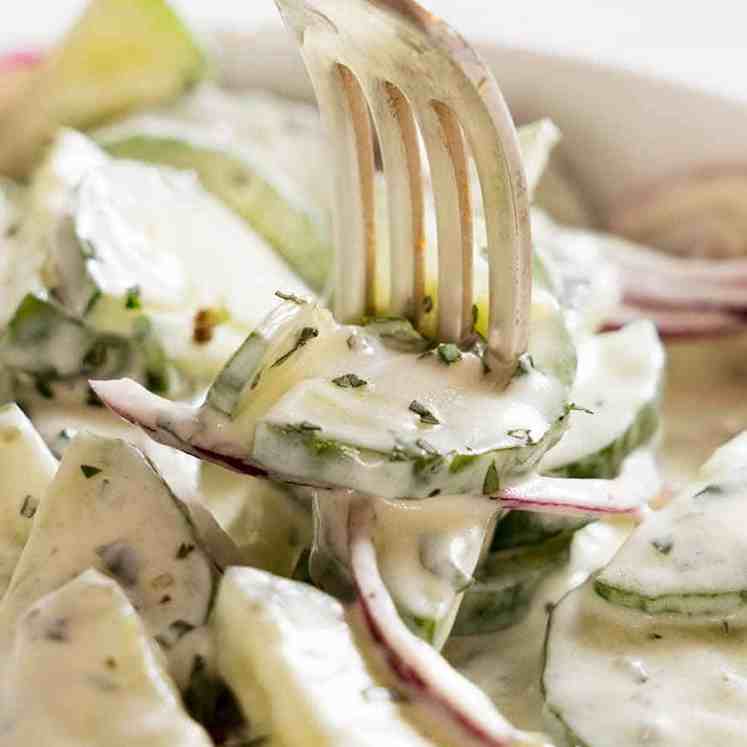 Close up of fork picking up Cucumber Salad with Lemon Mint Yogurt Dressing