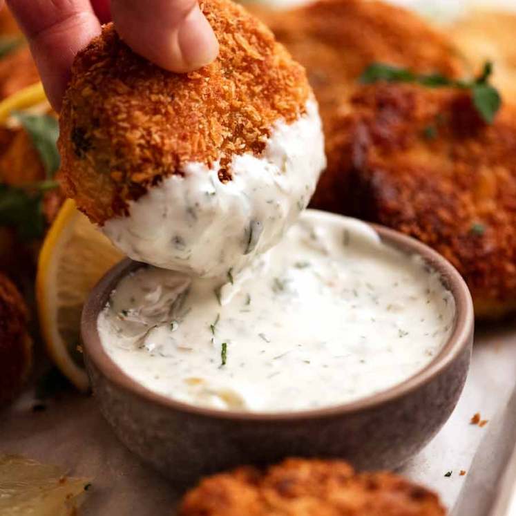 Dipping Fish cakes in tartare sauce