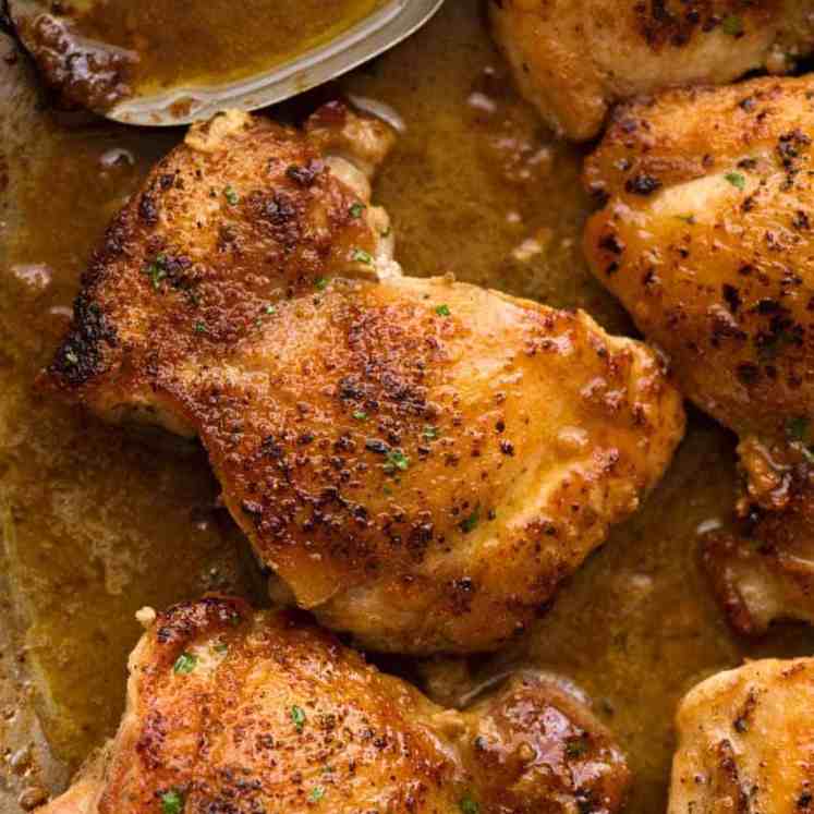 Close up of Crispy Garlic Chicken Thighs in a skillet with garlic butter sauce, ready to be served