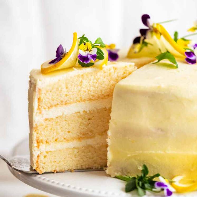 Pulling out a slice of Lemon Cake with Fluffy Lemon Frosting