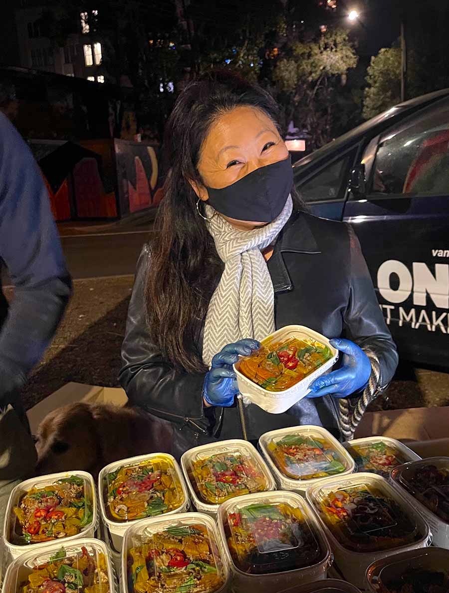 Nagi Maehashi at meal distribution site, holding meal